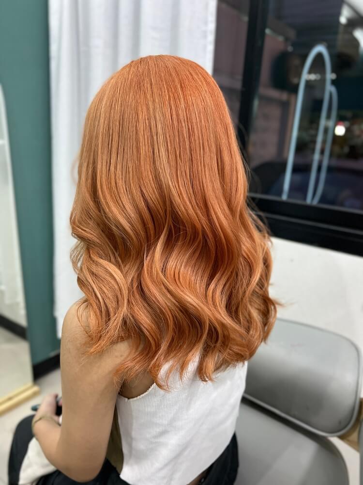 A woman with short, wavy strawberry blonde hair.