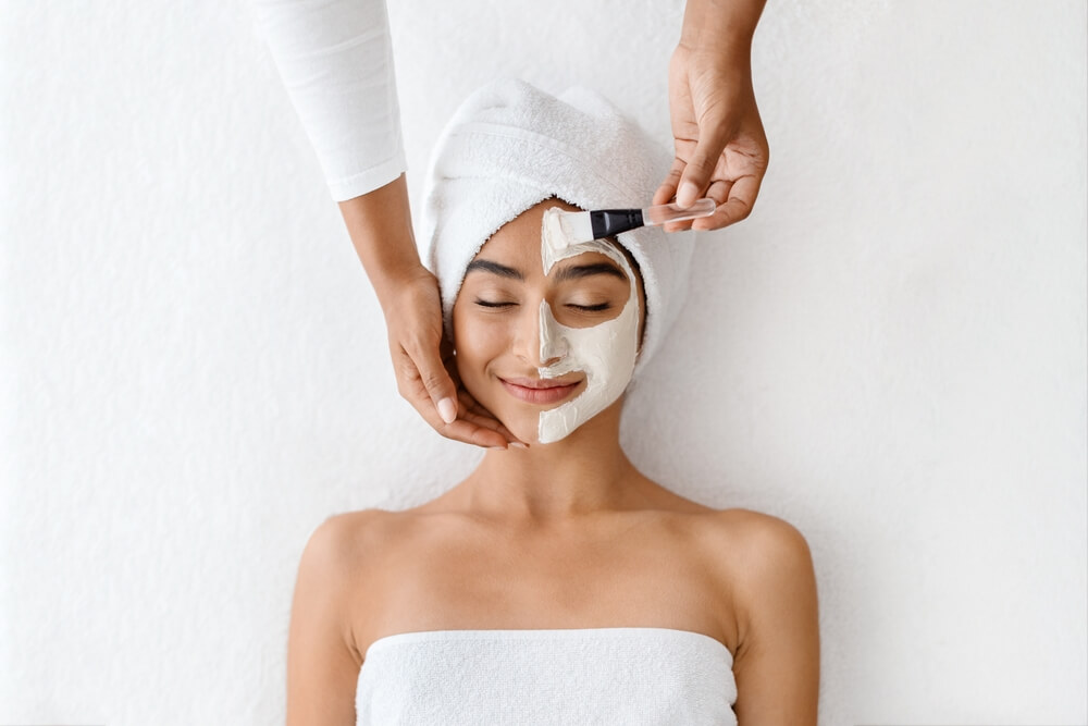 A woman enjoying professional facial services at home.
