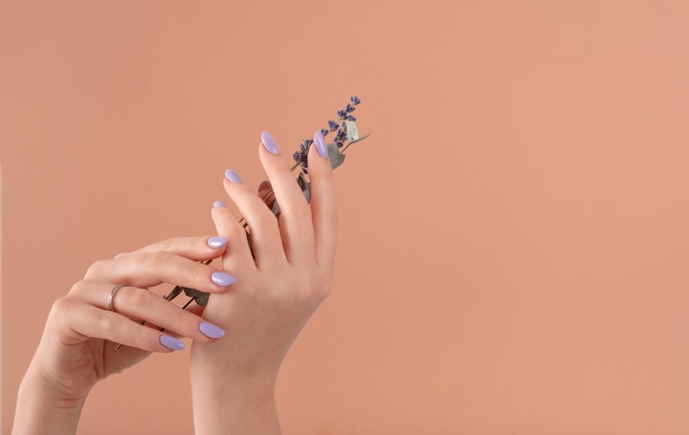 A woman showing off her healthy and beautiful nails from expert treatments.